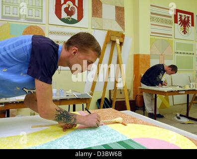 (dpa) - Apprentice Steffen Schueler (21), who learns the craft of a painter and varnisher, practises on a piece of work at the education centre of the construction industry in Frankfurt Oder, eastern Germany, 27 August 2003. In addition to their apprenticeship in companies, apprentices in Germany ha Stock Photo