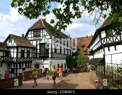(dpa) - Tourists visit Wartburg Castle located above the town of Eisenach, Germany, 30 July 2003. Although the Wartburg has retained some original sections from the feudal period, it acquired its form during the 19th century reconstitution. It was during his exile at Wartburg Castle that Martin Luth Stock Photo