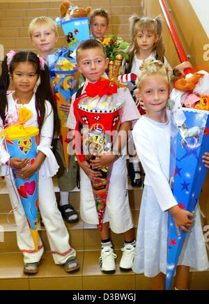 (dpa) - The first graders proudly pose with their school cornets on their first day at school in Magdeburg, Germany, 23 August 2003. As a tradition, first-graders in Germany get from their parents a cornet filled with sweets for their first day at school. Stock Photo