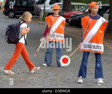 (dpa) - A pupil crosses a street protected by two senior student crossing guards ('Schuelerlotse') in the district of Steglitz, in Berlin, 22 August 2003. Crossing guards have been on duty for 45 years in Berlin, and especially in the big cities guard the first graders and pupils of elementary schoo Stock Photo