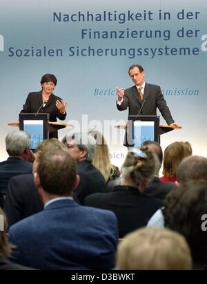 (dpa) - German Health Minister Ulla Schmidt (L) and Bert Ruerup, Chairman of the commission of inquiry, stand underneath the title 'sustainability in the financing of the social security systems' at a press conference in Berlin, 28 August 2003. Painful changes to Germany's cradle-to-the-grave welfar Stock Photo