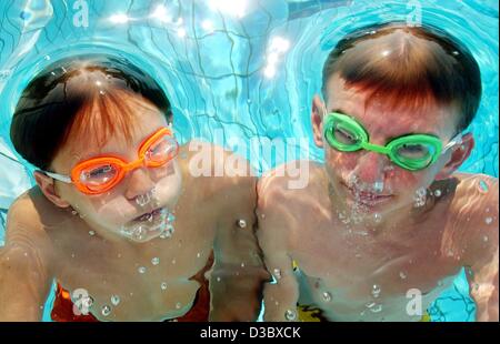 (dpa) - Extraterrestrials in Germany? Two boys wear each a pair of orange and green diving goggles while they dive underwater and blow bubbles in the swimming pool in Frankfurt Main, Germany, 13 August 2003. Water rats would prefere to stay in water for good with temperatures above 30 degrees Celsiu Stock Photo