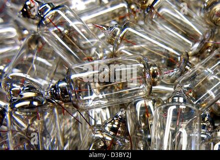 (dpa) - Coming out of a meltdown pressure machine a heap of low voltage light bulbs are still to receive their electric contacts, at the production site of the light bulb manufacturer Narva-Golux in Oberweissbach, Germany, 11 June 2003. The small light bulbs are used for car lights, signal lights, i Stock Photo