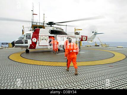 (dpa) - Workers board a helicopter which will carry them back to the mainland, on a gas and oil rig in the North Sea, about 250 km offshore of Stavanger, Norway, 5 July 2003. The platform belongs to the Ekofisk field complex, which comprises the oil and gas rigs Ekofisk, Eldfisk, Embla and Tor. The  Stock Photo