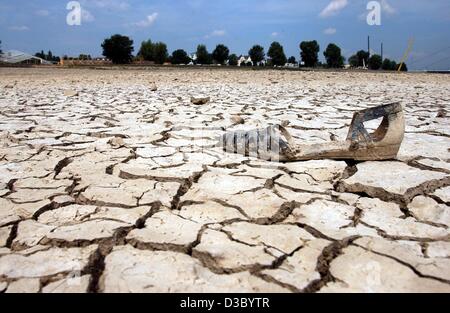 (dpa) - A shoe lies on the dry and cracked soil on the banks of the River Rhine in Duesseldorf, Germany, 23 July 2003. Due to the dry weather over the past months the water levels sank in most German rivers, bringing freight shipping on most rivers to a halt. Stock Photo