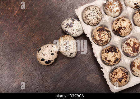 many fresh speckled quail eggs in cardboard container on wooden Stock Photo