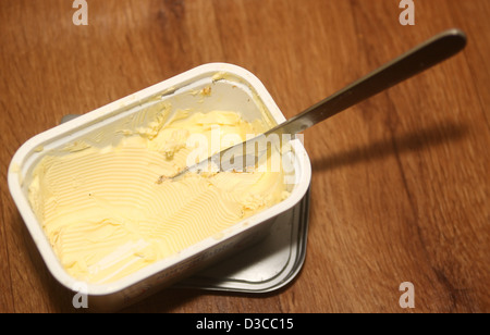 Knife in tub of spreadable butter Stock Photo