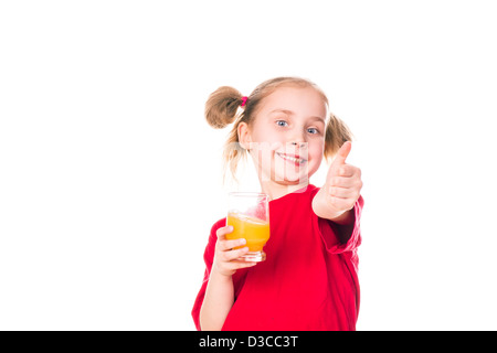 Cute little girl holding glass with juice smiling with thumb up isolated on white Stock Photo