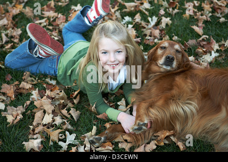 Eight year old playing with her Golden Retriever dog Stock Photo