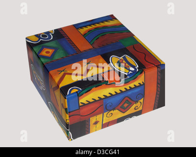 Cardboard box with bright and colourful geometric design - for packaging or gift - against plain off-white background Stock Photo