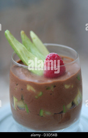 A chocolate & avocado mousse dessert topped with a raspberry & avocado garnish Stock Photo