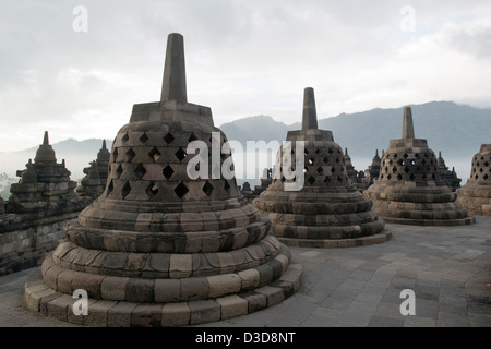 Chortens containing hidden Buddha statues sit on the uppermost plinth of the Borobudur Buddhist temple in Java, Indonesia Stock Photo