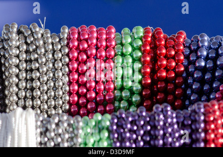 Thousands of strands of glass beads in a wide variety of colors are on display in the afternoon sunlight. Stock Photo