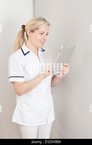 Blonde female nurse (dental) using a digital tablet. Stock Photo