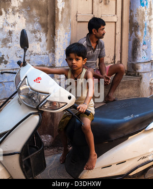 young Indian boy sitting on a motorbike, Varanasi, India Stock Photo