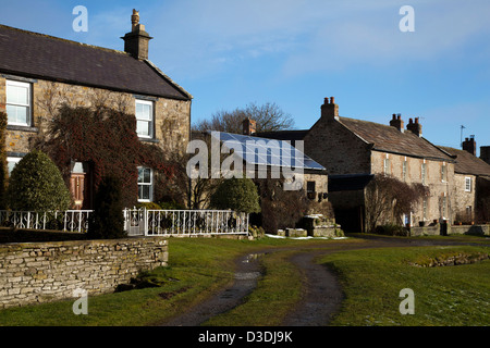 Detached stone-built houses with Solar Panels, in the village of Bellerby, Near Leyburn and Catterick, North Yorkshire, UK Stock Photo