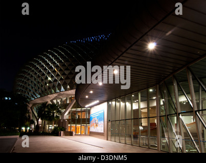 The exterior external entrance entry to the Esplanade Theatres On The Bay lit up at night, Marina Bay, Singapore Stock Photo