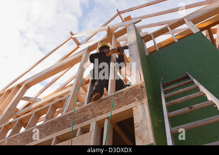 Carpenter using a reciprocating saw on house under construction Stock Photo