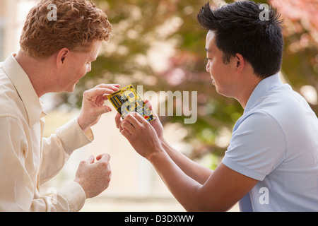 Two engineers talking about microchips on circuit board Stock Photo