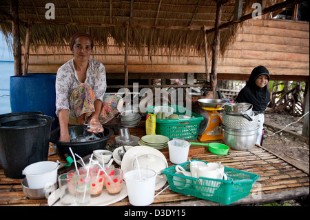 Koh Klang, Thailand, woman RINSING dishes Stock Photo