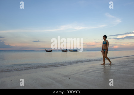 Phi Phi Iceland, Thailand, a woman in a bikini walking on the beach at night Stock Photo