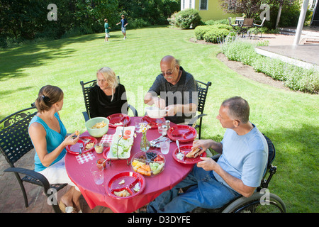 Man with spinal cord injury in wheelchair at family picnic with grandparents included Stock Photo