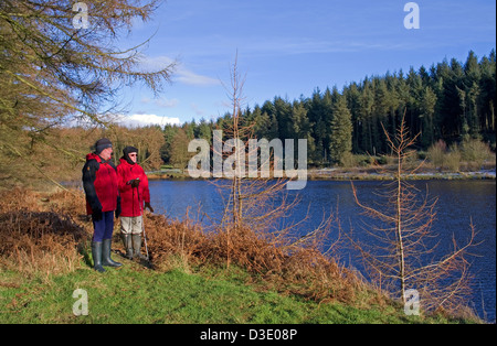 Two walkers looking across Cod Beck Reservoir, near Osmotherley, North York Moors National Park, North Yorkshire, England, UK Stock Photo