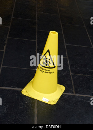 Yellow warning cone on dark floor Stock Photo