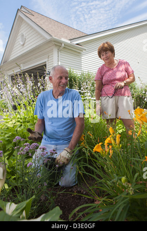 Senior couple preparing to plant flowers in garden Stock Photo