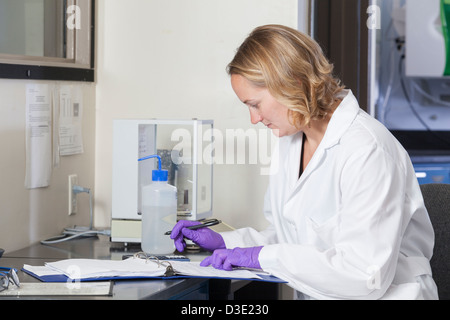 Laboratory scientist recording chemical analysis data in a laboratory Stock Photo