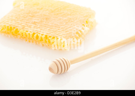 Full honey pot and honey stick over white and honeycomb Stock Photo