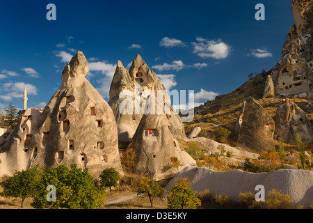 Ancient cave houses carved in volcanic tuff at Uchisar at sunset Cappadocia Turkey Stock Photo