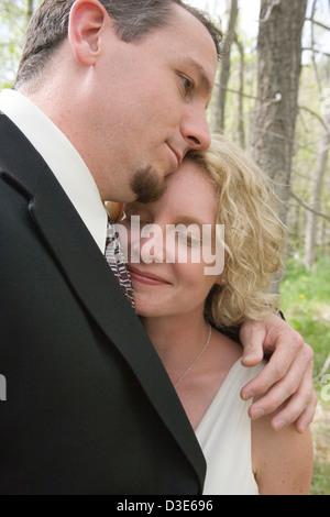 Bride and groom embrace, closeup. Stock Photo