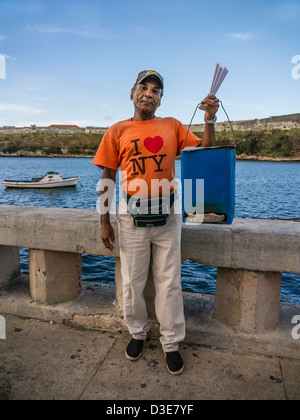 A Cuban middle-aged male peanut seller hawks his wares on the famous Malecon, in Havana, Cuba. Stock Photo