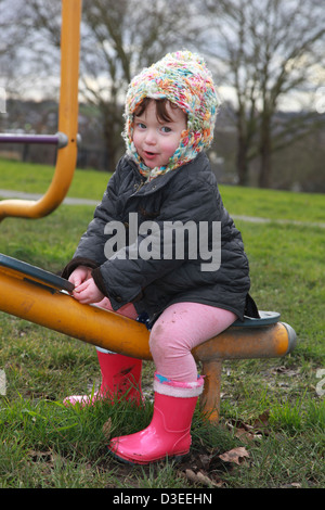 Toddler playing in the park in the winter, UK Stock Photo