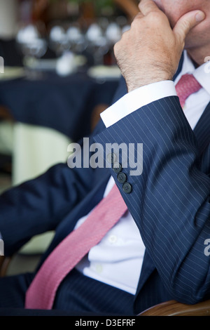 Businessman considering the situation seated a at table in a restaurant during a business lunch. Stock Photo
