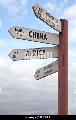 Crossroads sign indicating the distance to China, Africa North Pole and Strasbourg. Stock Photo