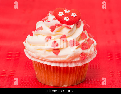 Cup cake decorated with a love and heart themed design - red background Stock Photo
