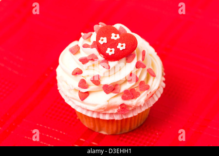 Cup cake decorated with a love and heart themed design - red background Stock Photo