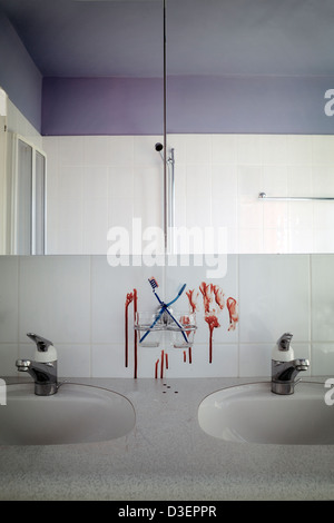 two toothbrushes in a bathroom with blood splatters Stock Photo
