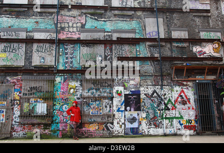 Female in front of colourful wall,Brick Lane, East London E1 Stock Photo