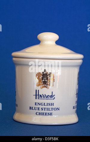 pot of Harrods Knightsbridge English blue Stilton cheese isolated on blue background Stock Photo