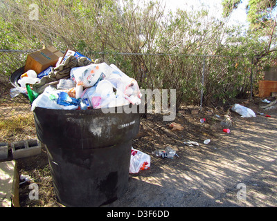 Residential garbage dumpster overflowing with trash Stock Photo