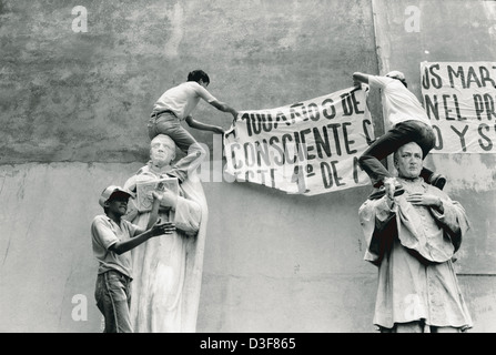 SAN SALVADOR, EL SALVADOR, 1st May 1986: Students put up banners in a church courtyard facing the square where 50,000 marchers have gathered to hear speeches. Stock Photo