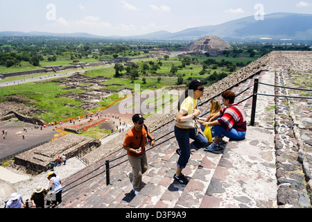 Tourists climbing the Pyramid of the Sun with the Avenue of the Dead and the Pyramid of the Moon in background. Teotihuacan