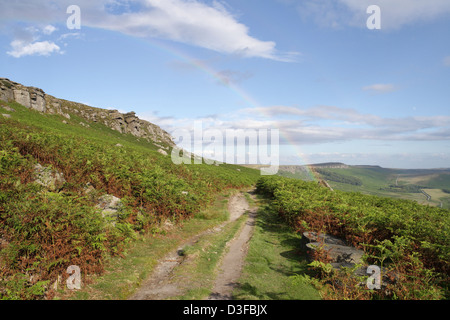 A rainbow over the path, High Neb on Stanage Edge in the Derbyshire Peak District England UK, British English countryside landscape scenic view Stock Photo