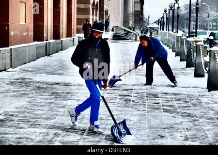 Men shoveling sidewalk in New Haven CT in front of City Hall Stock Photo