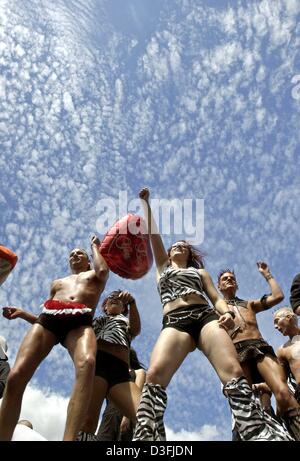 (dpa) - Techno fans dance on a float framed by the blue sky at the Love Parade in Berlin, Germany, 12 July 2003. Half a million scantily clad ravers danced through the heart of Berlin to the throbbing beat of the city's 15th annual Love Parade, billed as the world's biggest techno dance party. Pulsing music from 26 sound trucks reverberated as the parade of writhing bodies made its Stock Photo