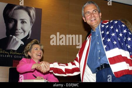 (dpa) - Hillary Rodham Clinton, US Senator and former First Lady, shakes hands with Ingo Segit wearing a stars and stripes jackes during the presentation of her book 'Living History' ('Gelebte Geschichte') in Berlin, 6 July 2003. On the last leg of a 10-day European tour the 55-year-old Clinton came to Berlin to promote her memoirs, but repeated she had no plans to run for the Amer Stock Photo