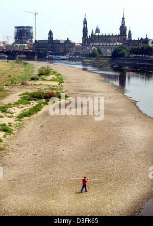 (dpa) - A surveyor walks through the dried out river bed of the River Elbe in Dresden, eastern Germany, 30 June 2003. The water depth gauge sank to 0.81 m due to continuing aridness. Stock Photo